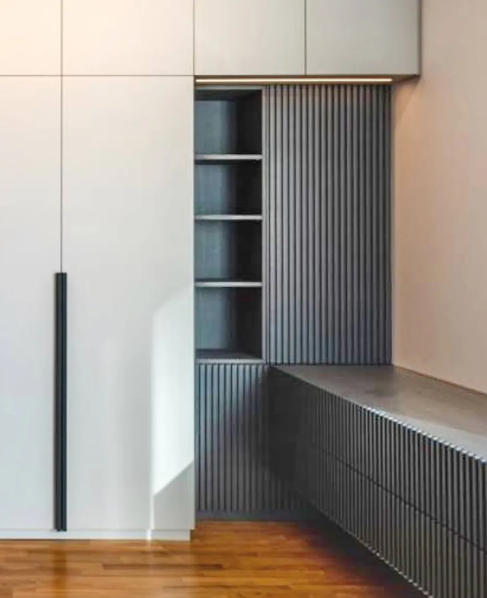 Einbauschrank mit Sitzbank und geriffelter Front in einem Flur